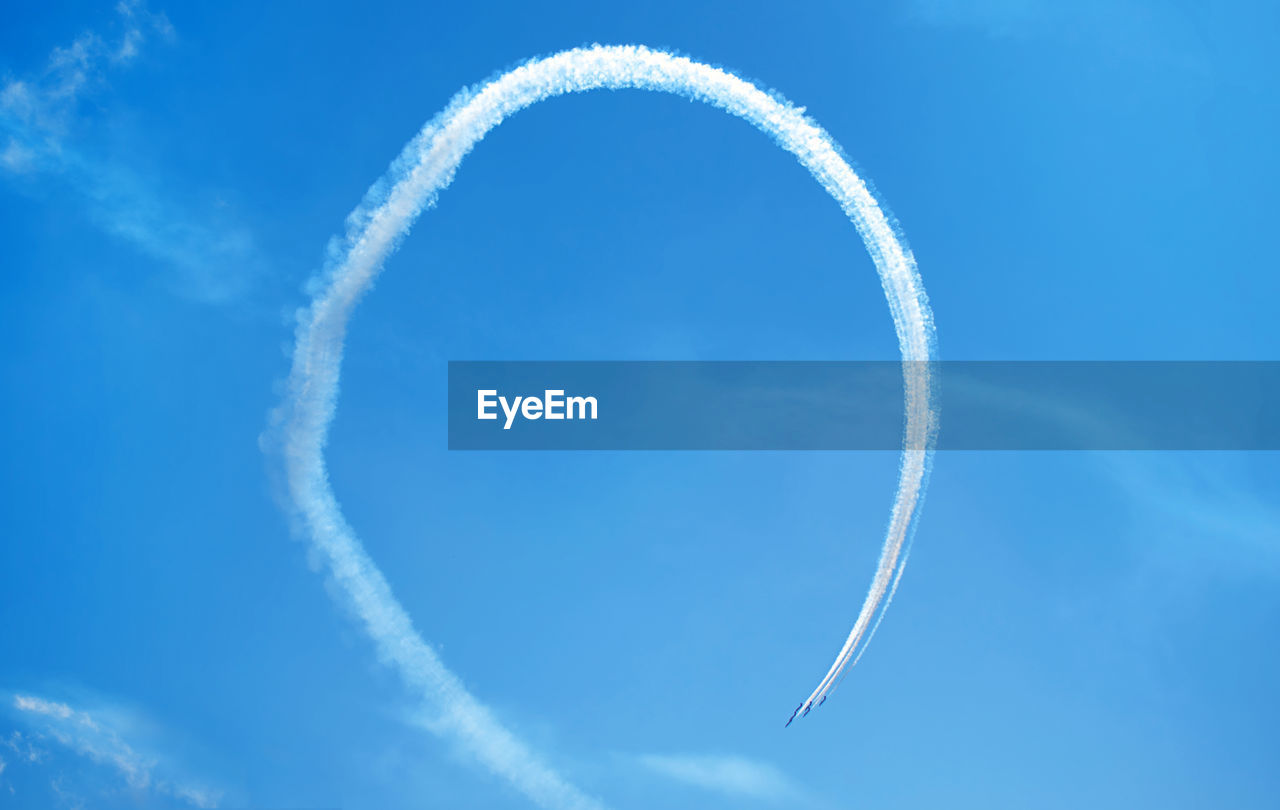 Low angle view of vapor trail against blue sky