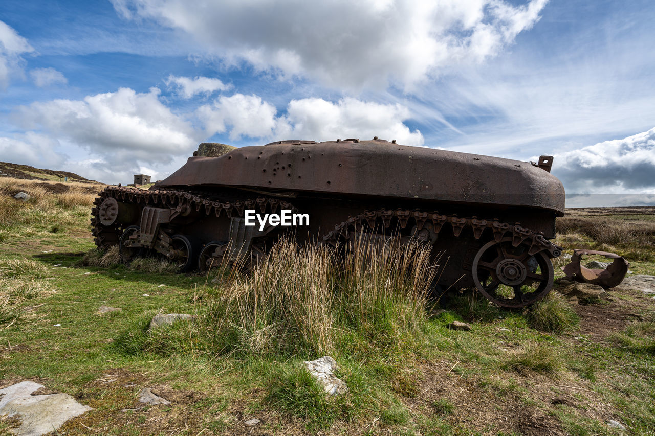 cloud, sky, transportation, mode of transportation, vehicle, landscape, nature, land, grass, abandoned, environment, tank, off-roading, metal, weapon, no people, plant, day, transport, motor vehicle, damaged, field, scenics - nature, non-urban scene, outdoors, rural area, old, military, rusty, land vehicle, history, the past, rural scene, mountain, travel