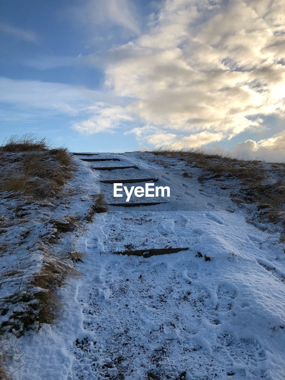 Scenic view of snow covered land against sky