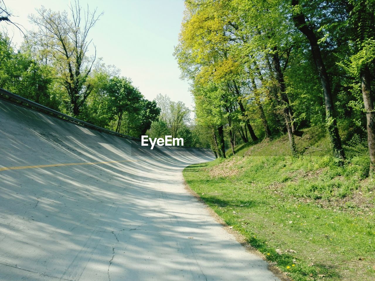 Road amidst trees against sky