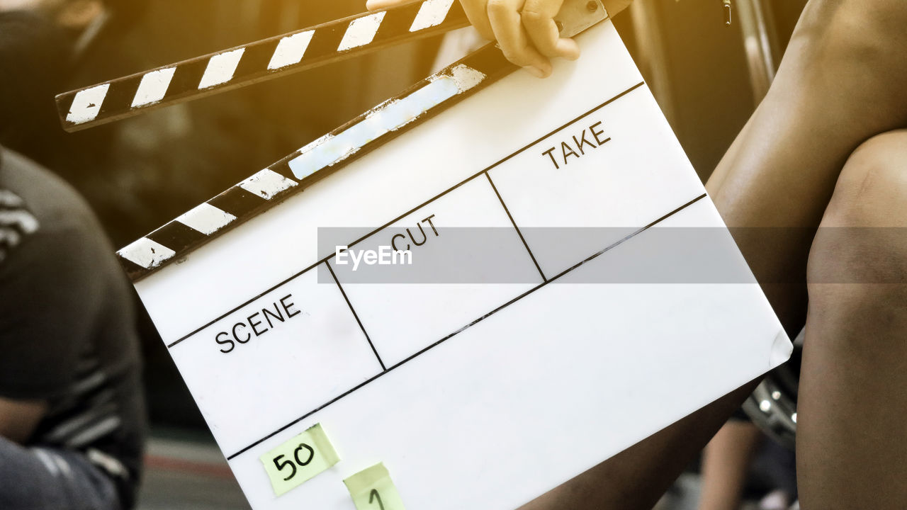 Cropped image of woman holding movie slate