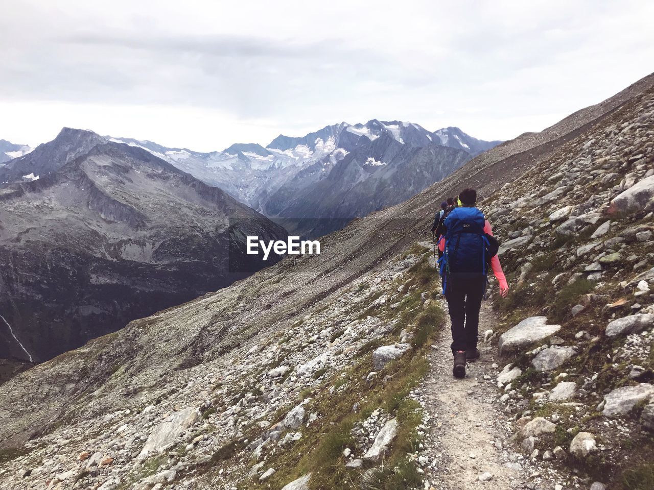 REAR VIEW OF MAN STANDING ON MOUNTAIN