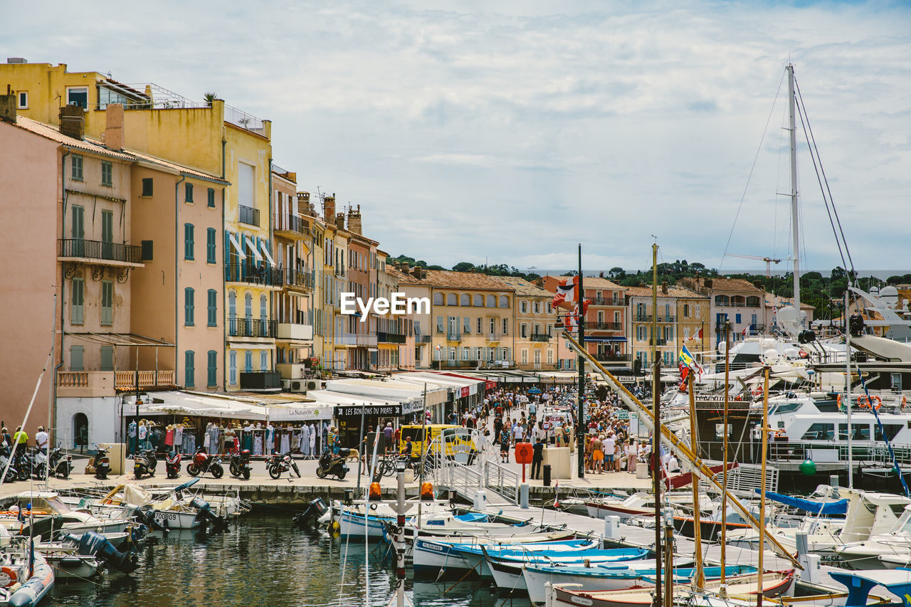 Boats moored on sea at marina grande against cloudy sky