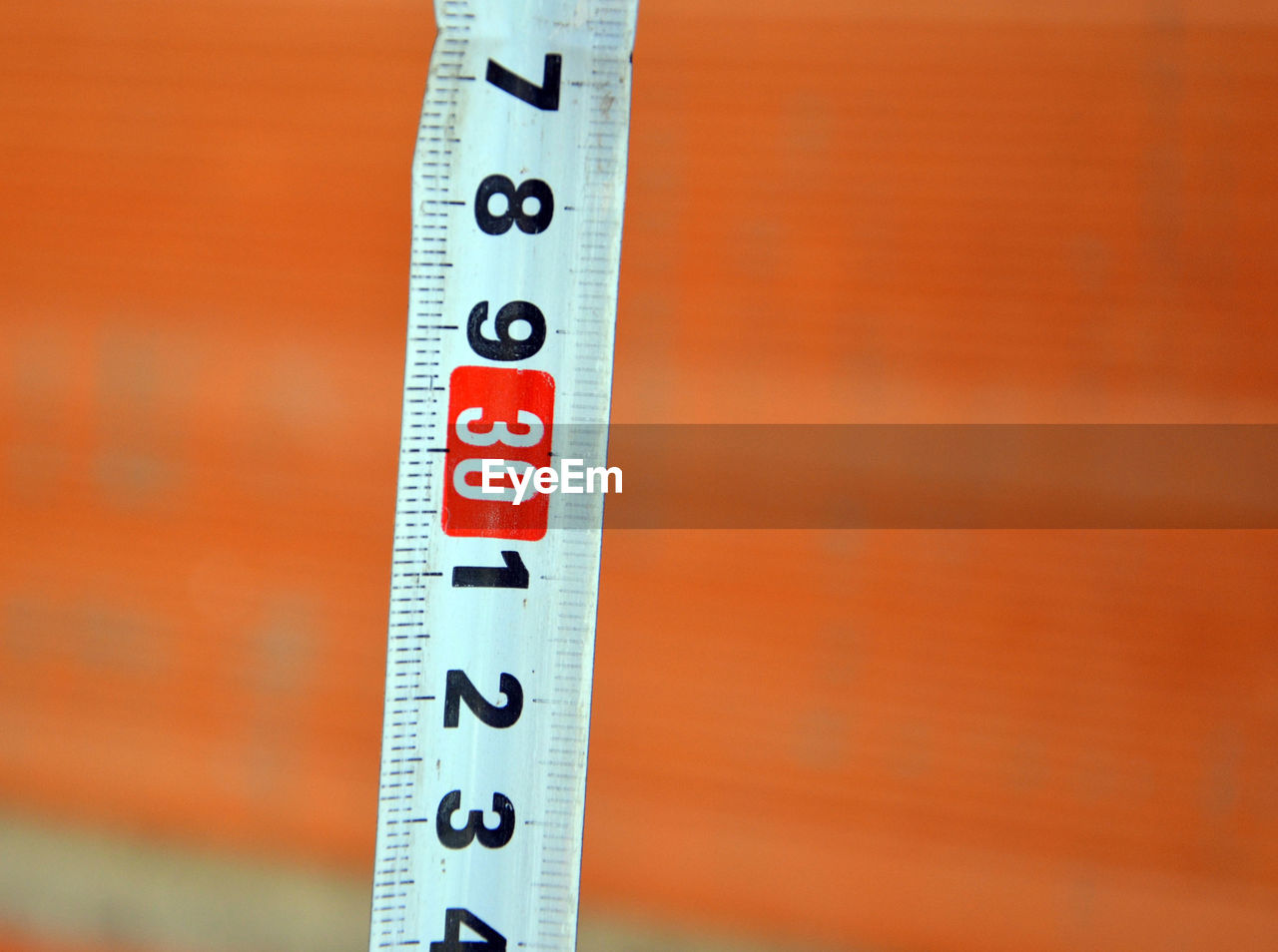 High angle close up of measuring tape against brick wall