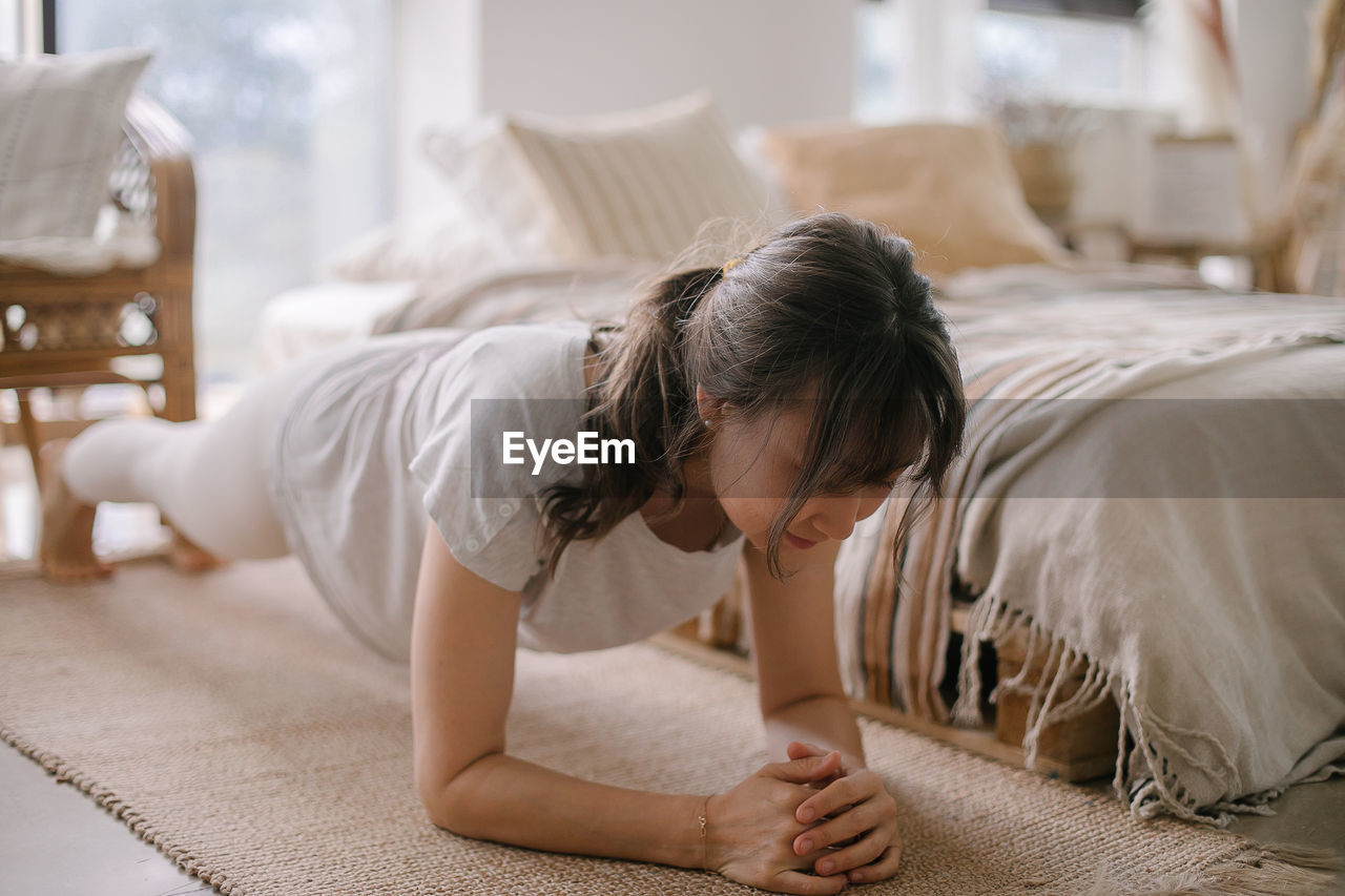 Side view of boy sleeping on bed at home