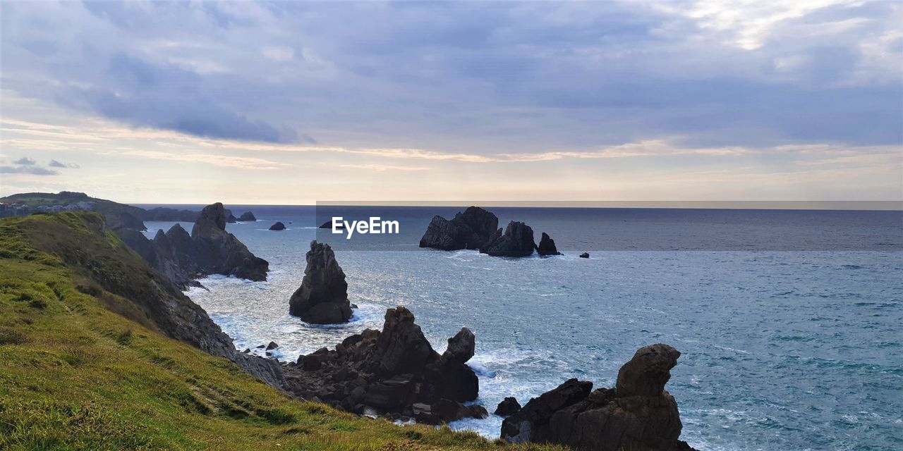 Scenic view of rocks in sea against sky