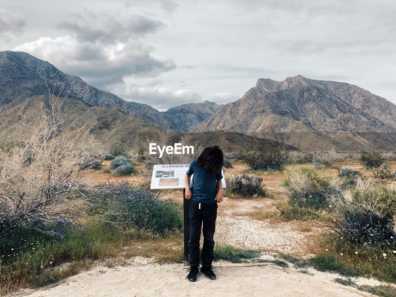 FULL LENGTH REAR VIEW OF MAN STANDING ON MOUNTAIN