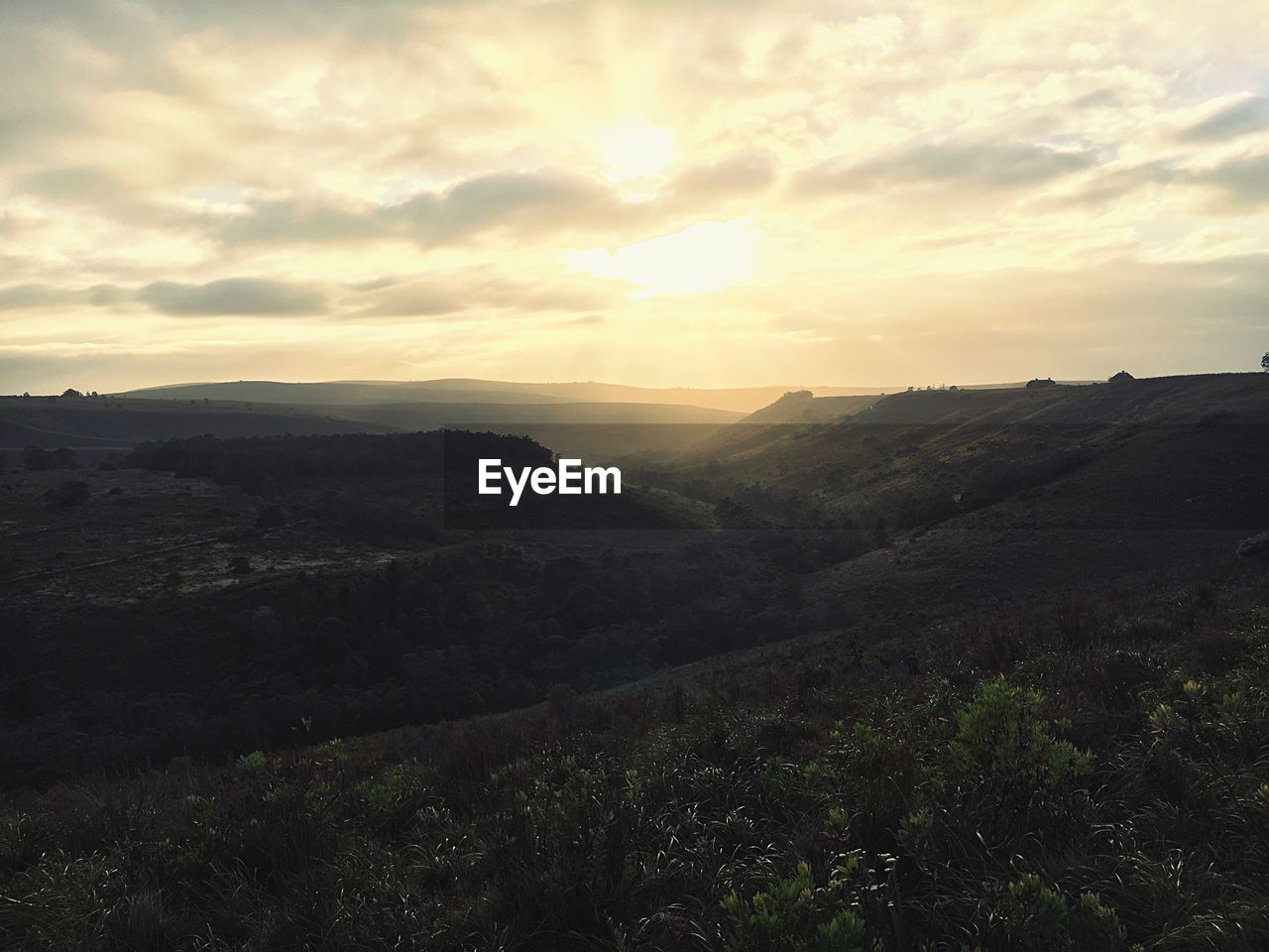 Scenic view of landscape against cloudy sky