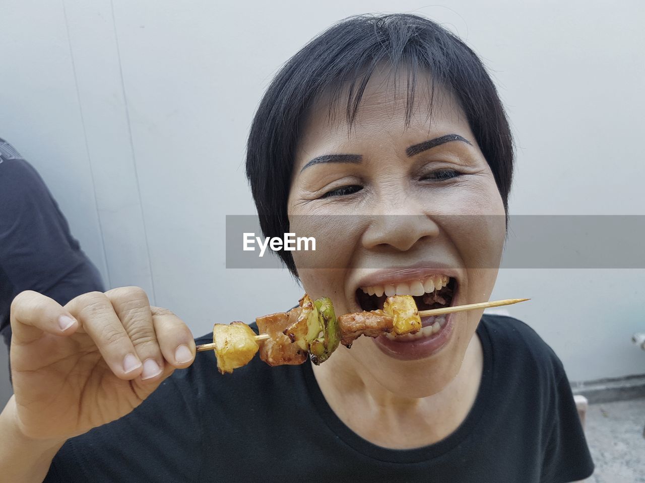 High angle view of woman eating from skewer