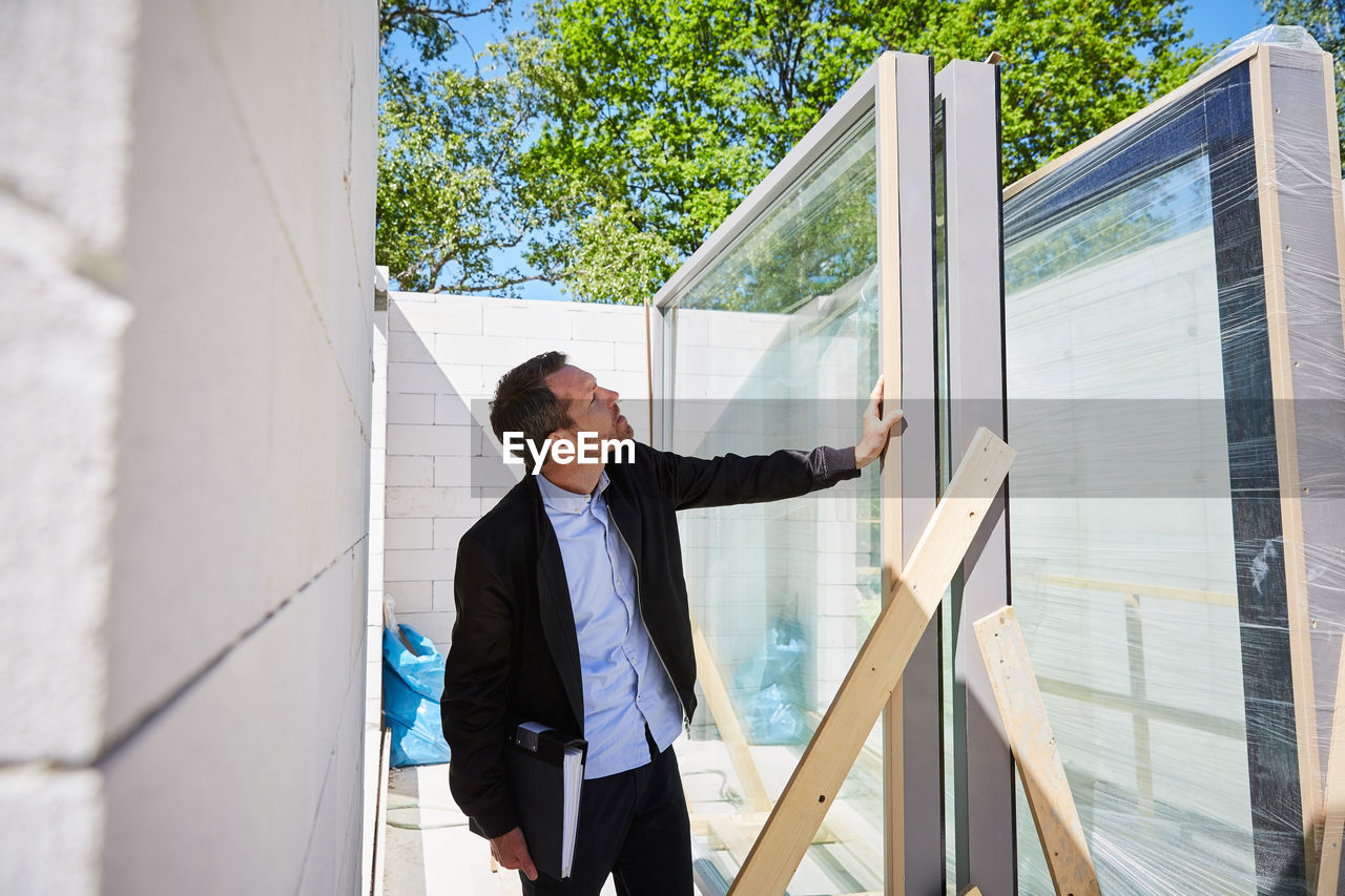 Architect with file analyzing at construction site on sunny day