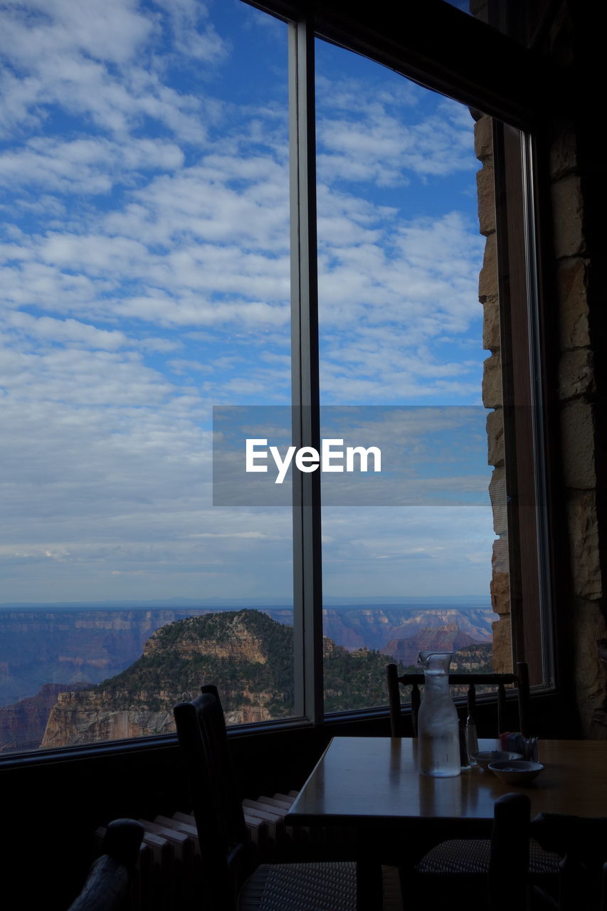 Scenic view of mountains against sky seen through glass window