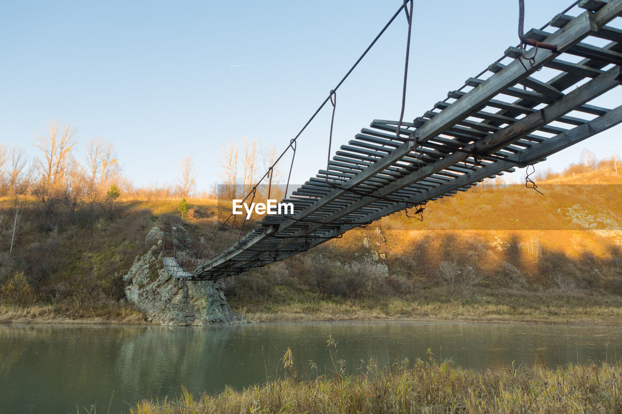 BRIDGE OVER LAKE AGAINST SKY