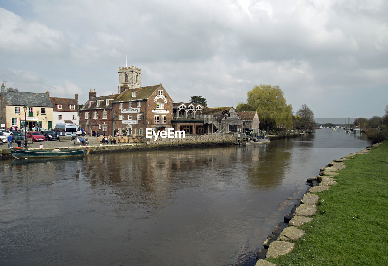 HOUSES BY RIVER AGAINST BUILDINGS