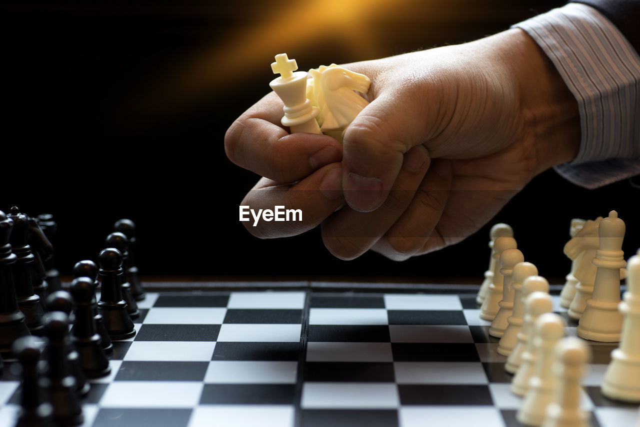 Cropped hand playing chess at home