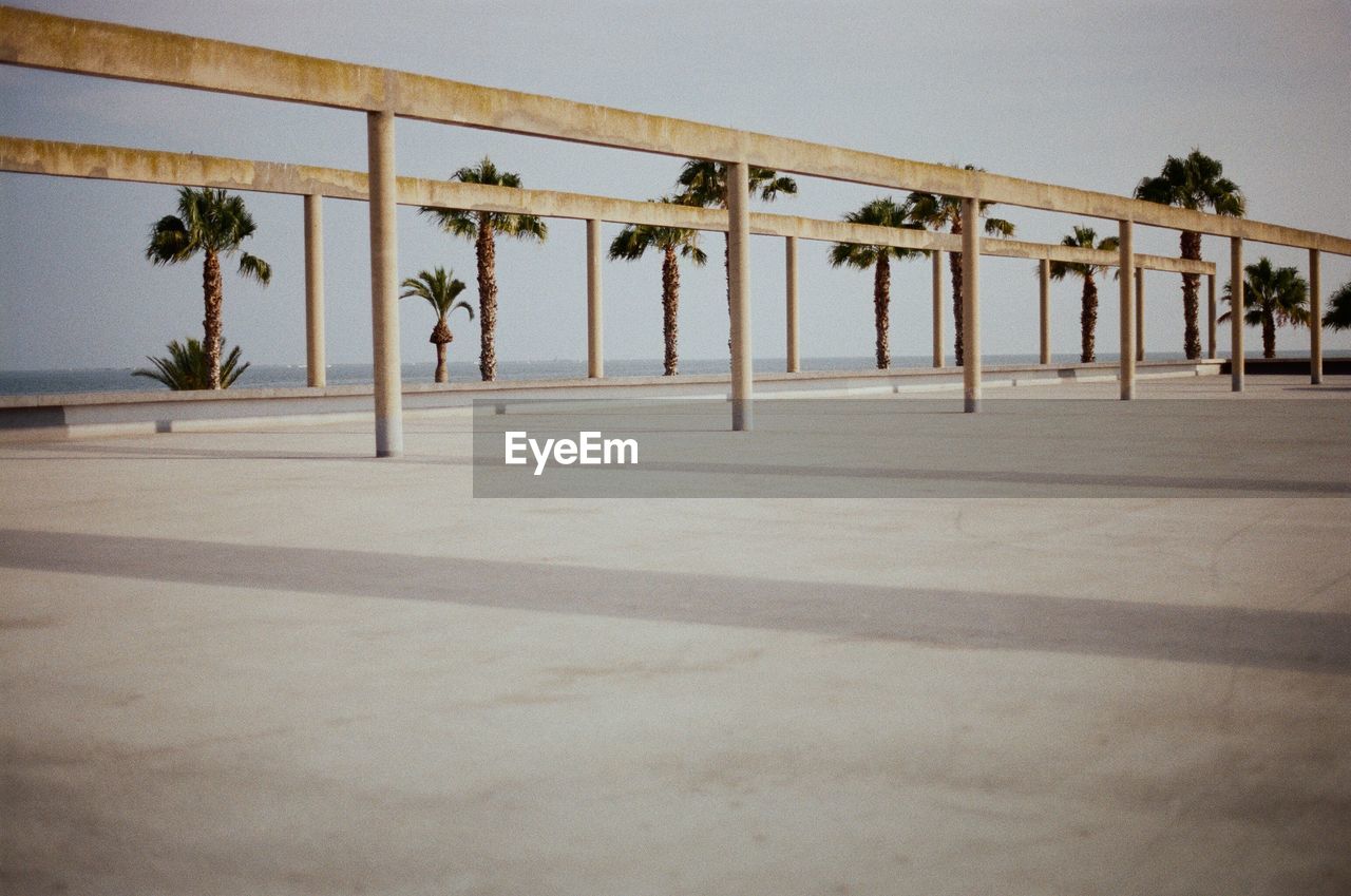 Built structure against palm trees and clear sky