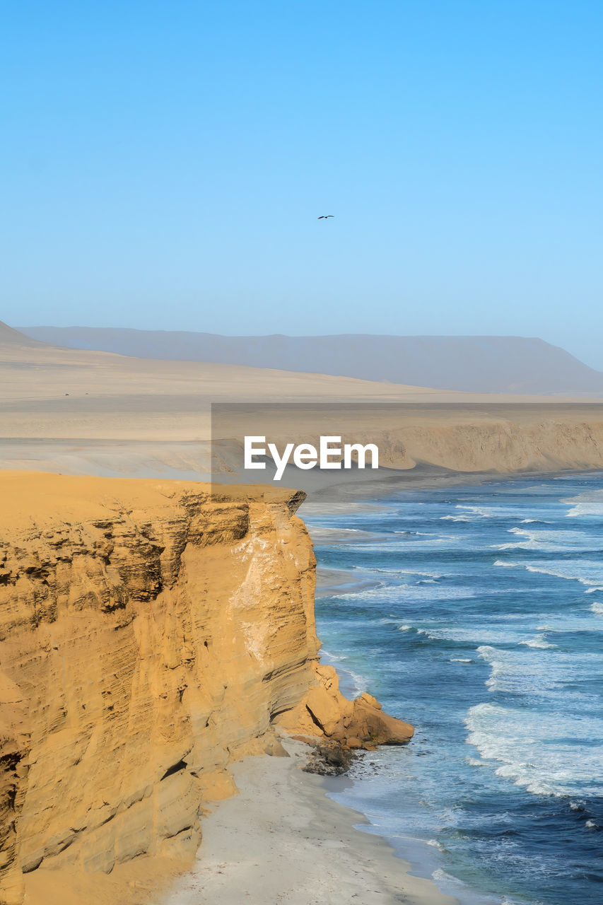 scenic view of beach against clear sky during sunset