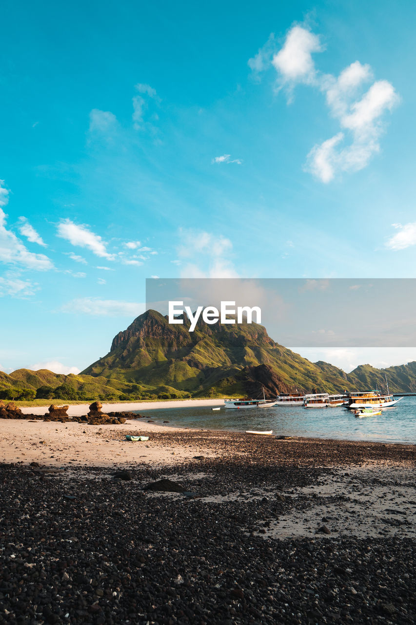 SCENIC VIEW OF BEACH BY MOUNTAINS AGAINST SKY
