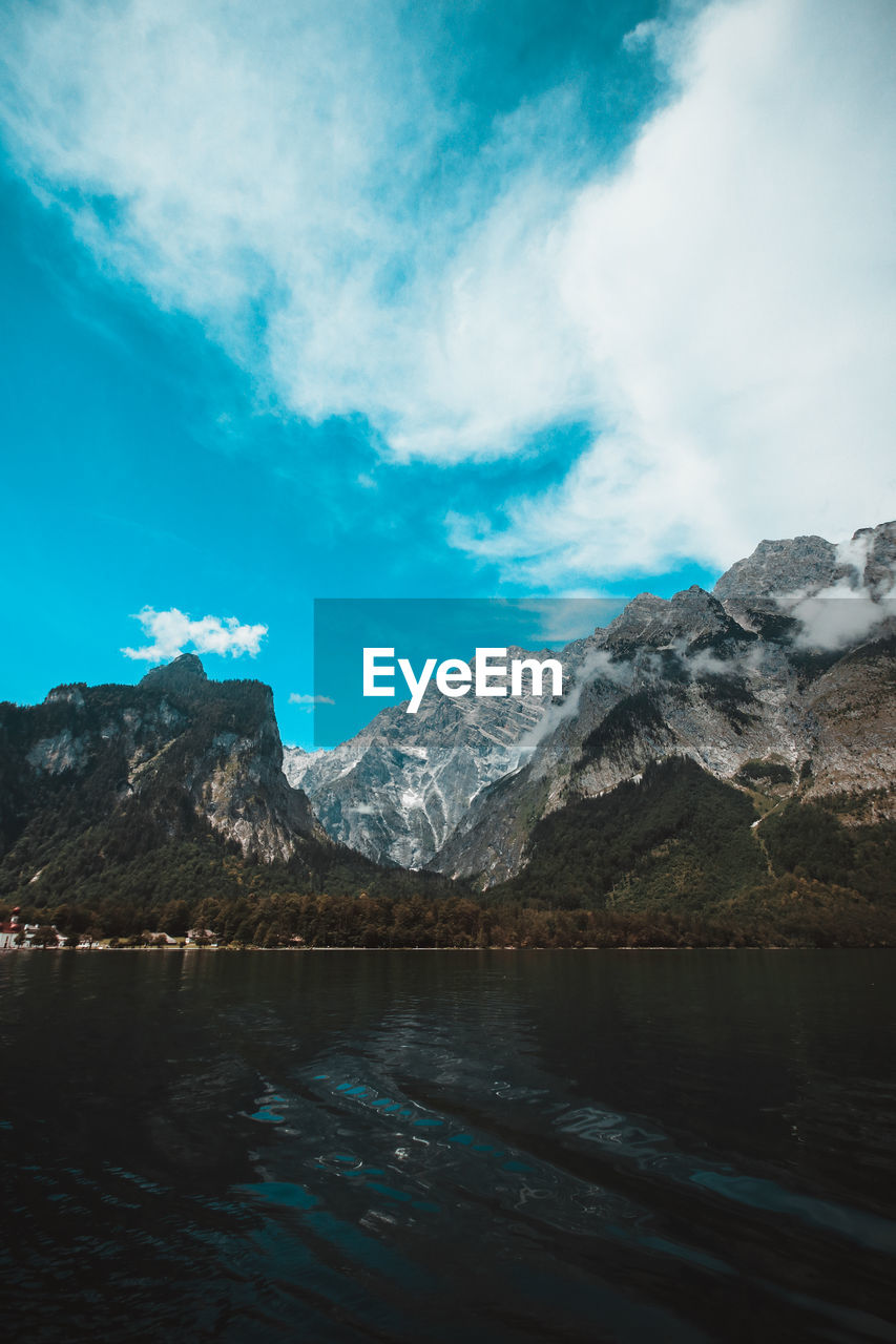 Scenic view of lake and mountains against blue sky