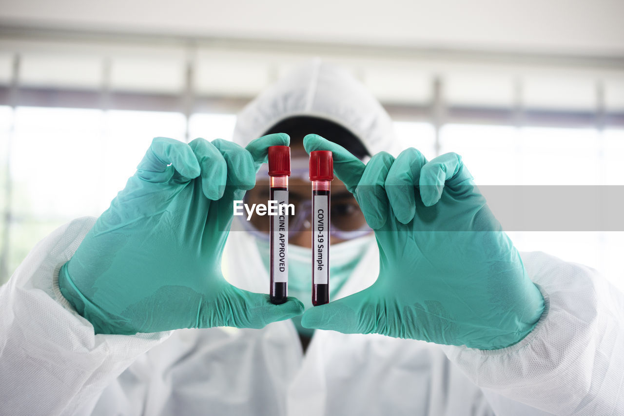 Portrait of scientist holding blood in containers