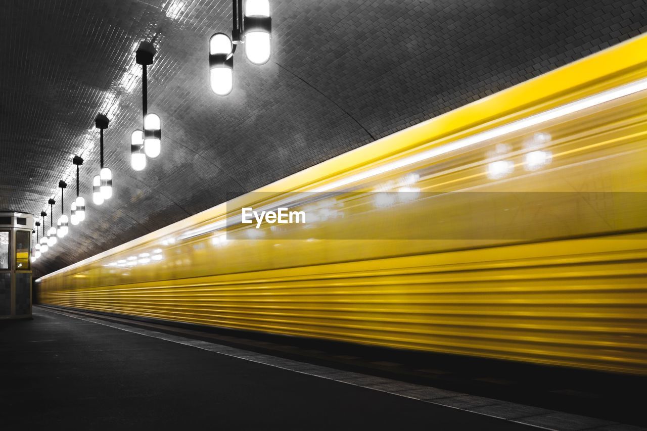 BLURRED MOTION OF TRAIN ON ILLUMINATED SUBWAY STATION