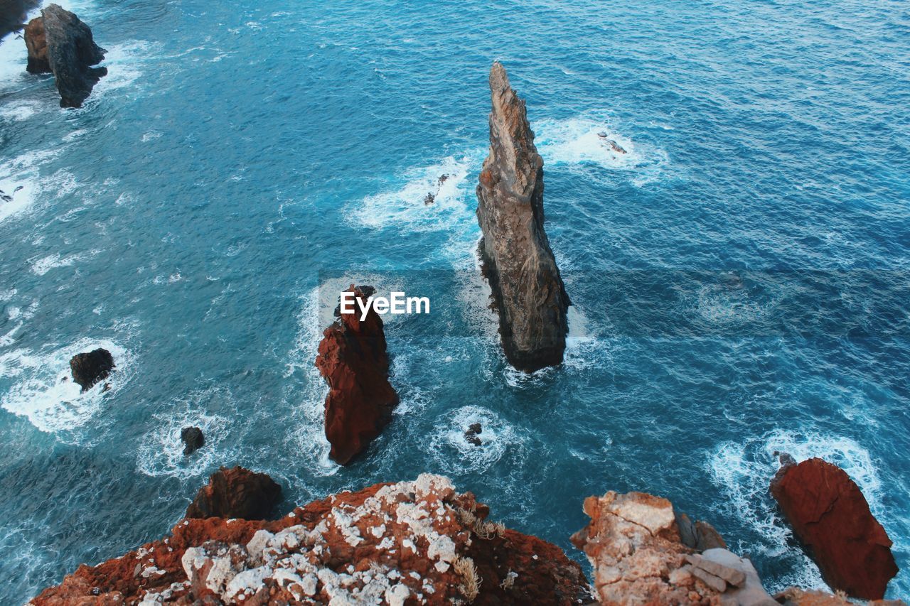 HIGH ANGLE VIEW OF ROCK FORMATION ON SEA