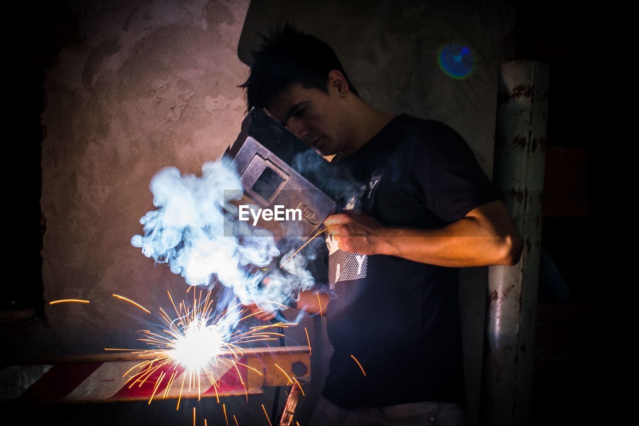 Man welding metal in workshop