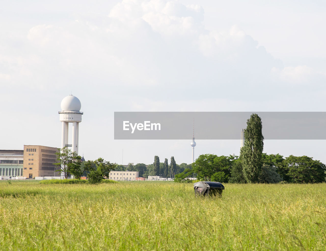 Control tower at airport in city against sky seen from tempelhofer feld park