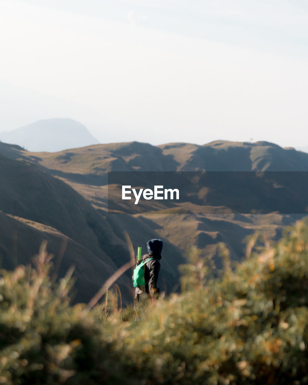 Side view of person on mountain against sky