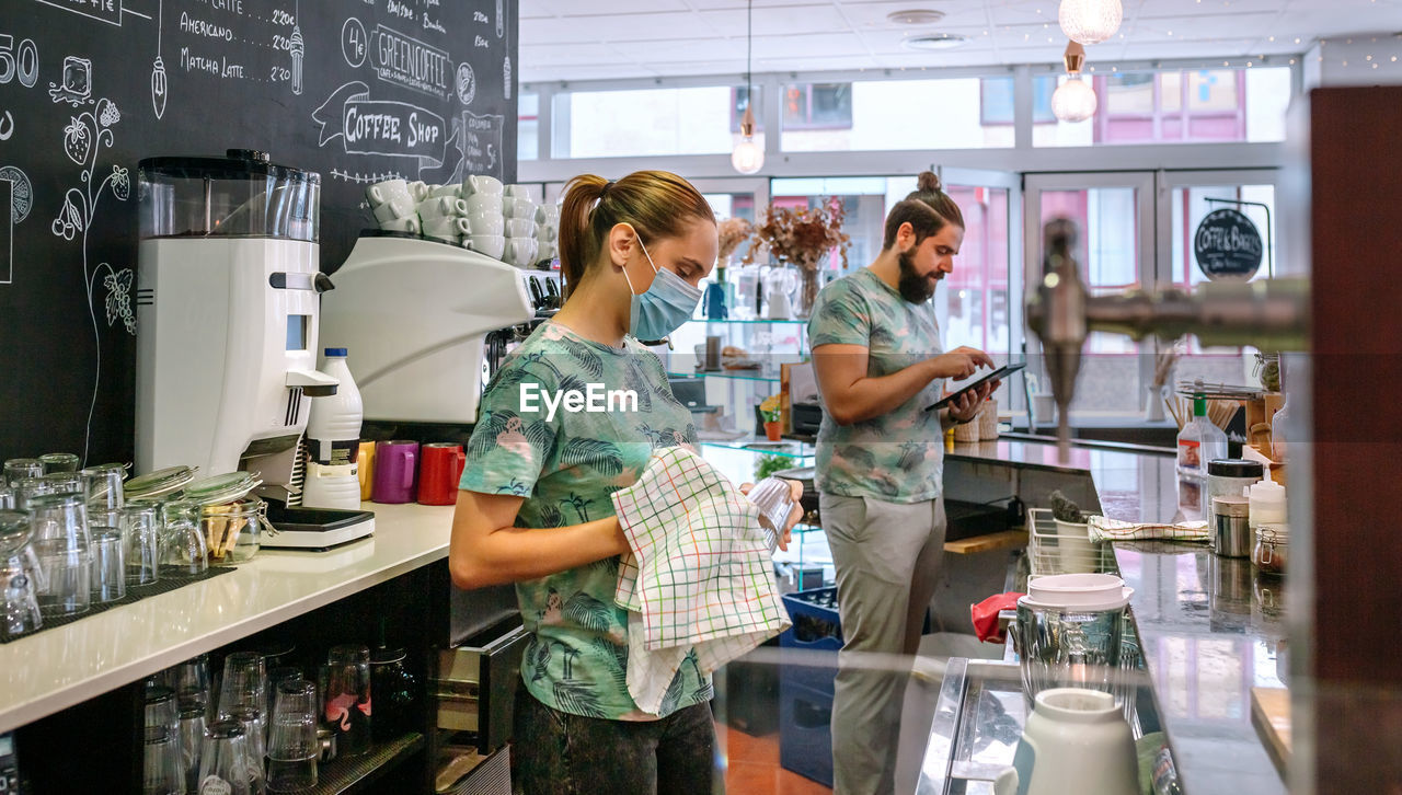 Waiter and waitress working at cafe