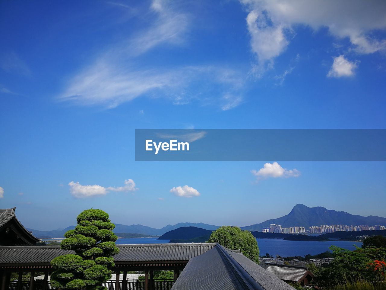 Scenic view of buildings and mountains against blue sky