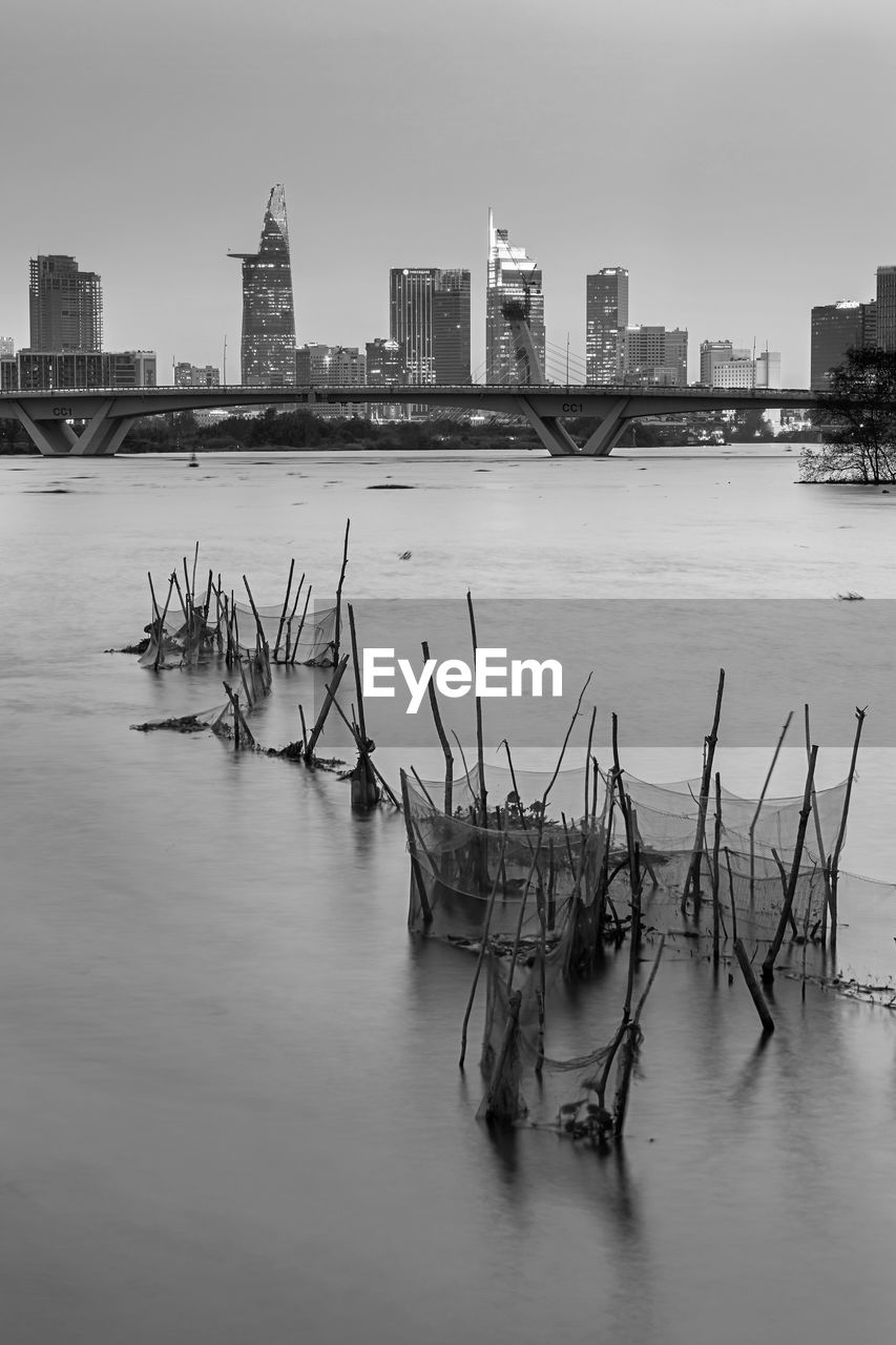 RIVER BY BUILDINGS AGAINST SKY IN CITY