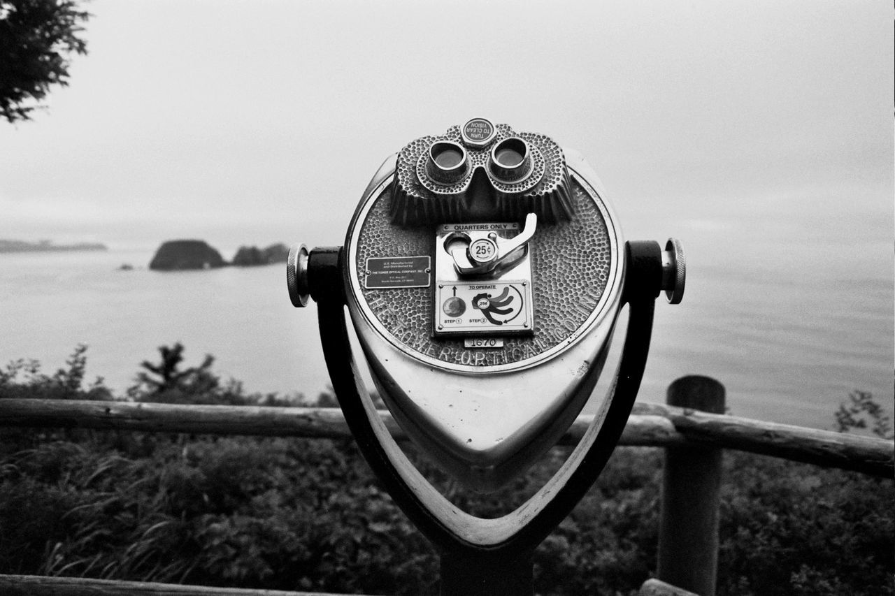 Close-up of coin operated binoculars by lake