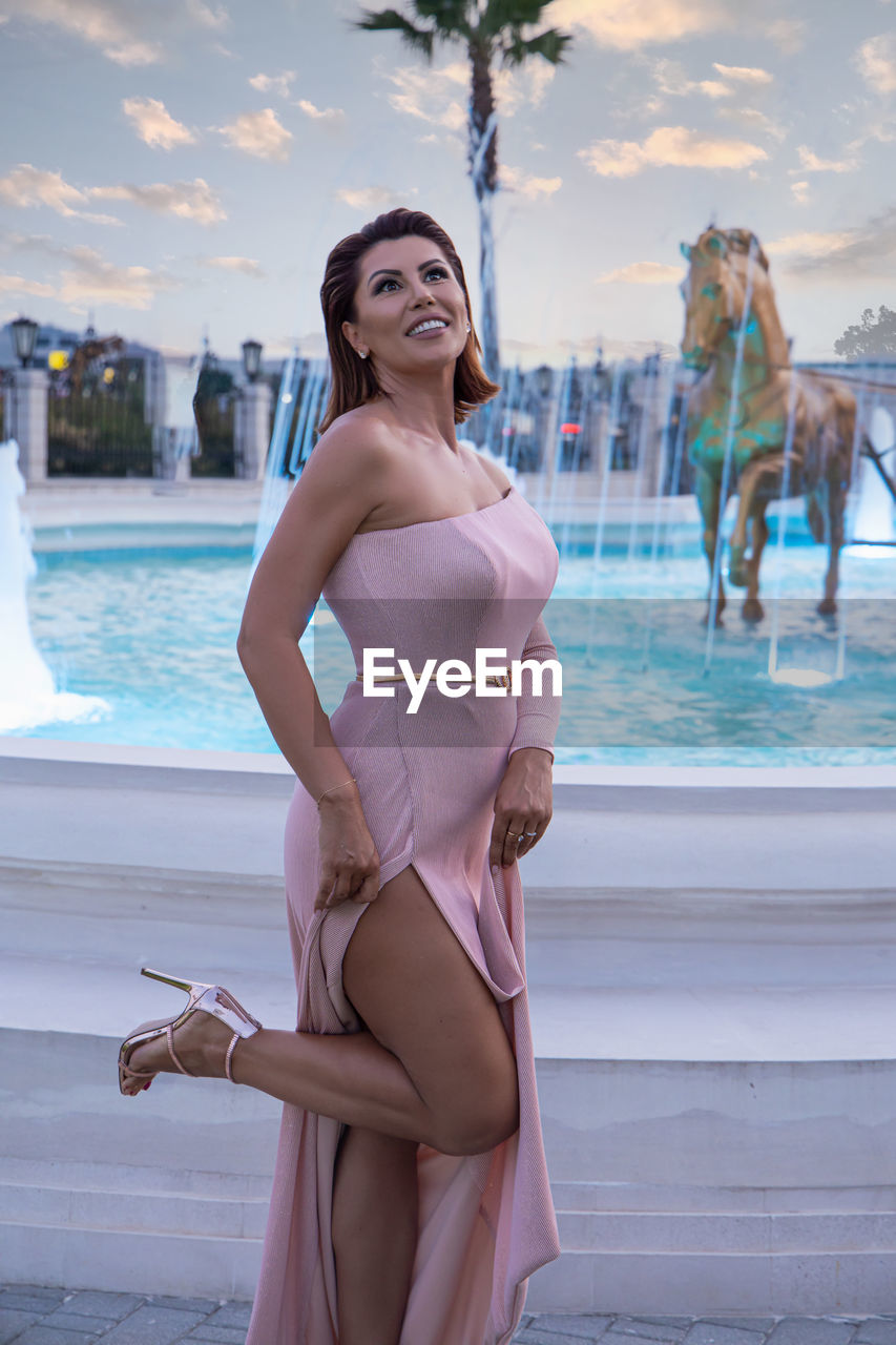 WOMAN STANDING IN SWIMMING POOL