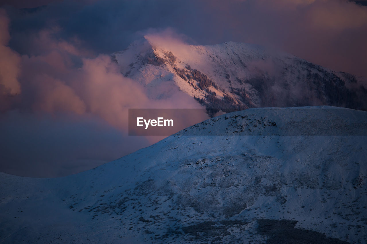 Scenic view of snowcapped mountains against sky during sunset