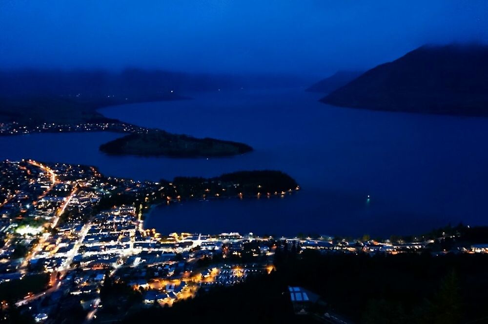 AERIAL VIEW OF ILLUMINATED CITYSCAPE AT NIGHT