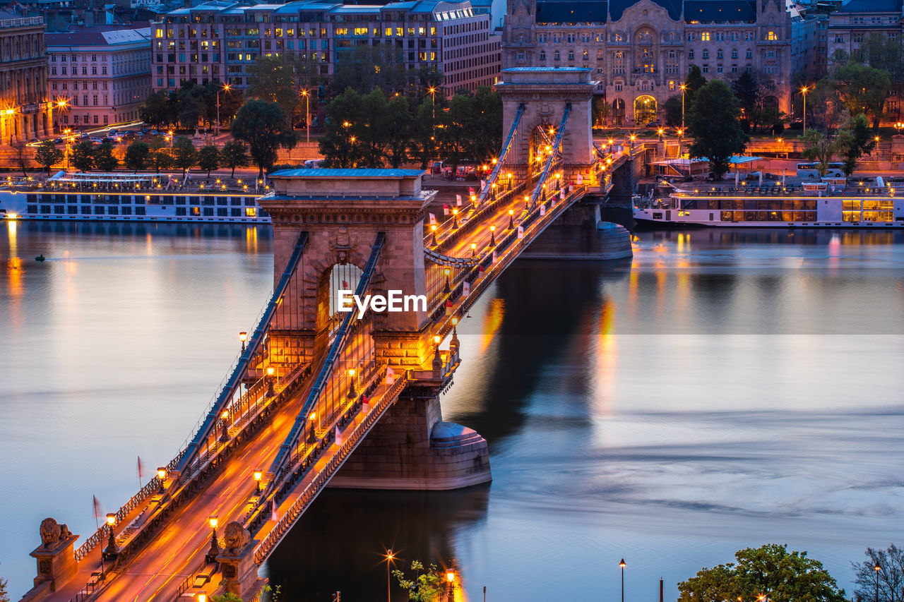 High angle view of illuminated bridge over river at dusk