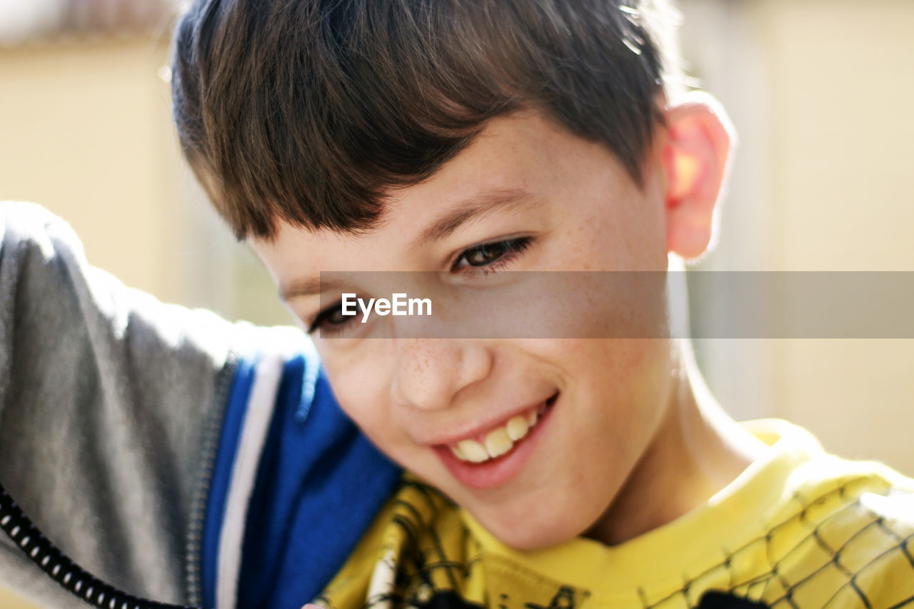 Close-up of cute smiling boy playing outdoors