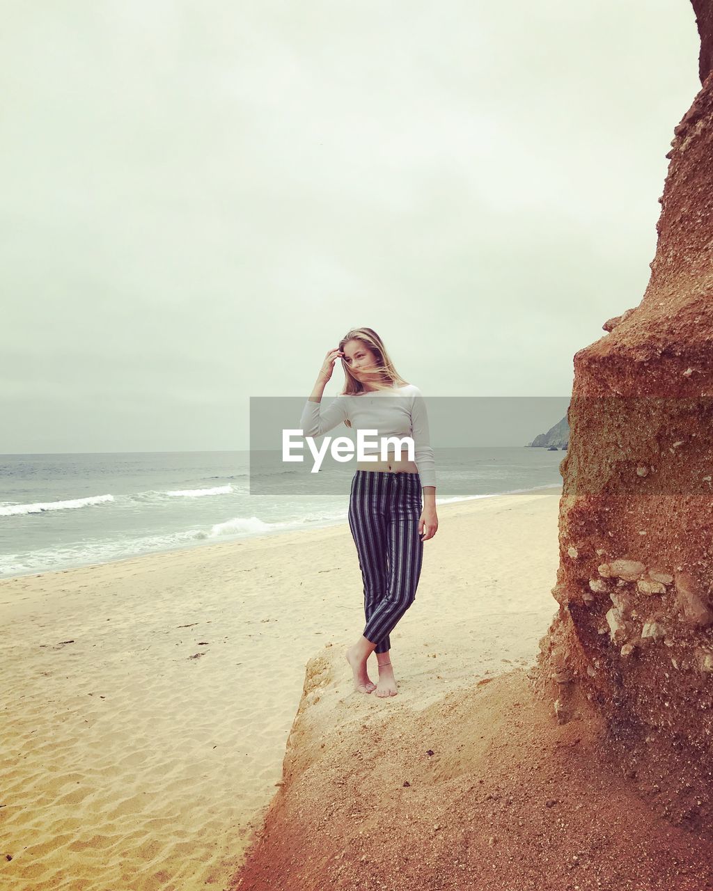 Full length of girl standing at beach against sky