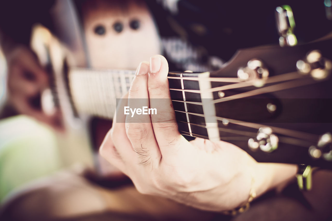 Cropped hands of man playing guitar