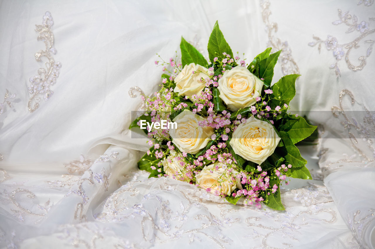 CLOSE-UP OF WHITE ROSE BOUQUET ON FLOOR