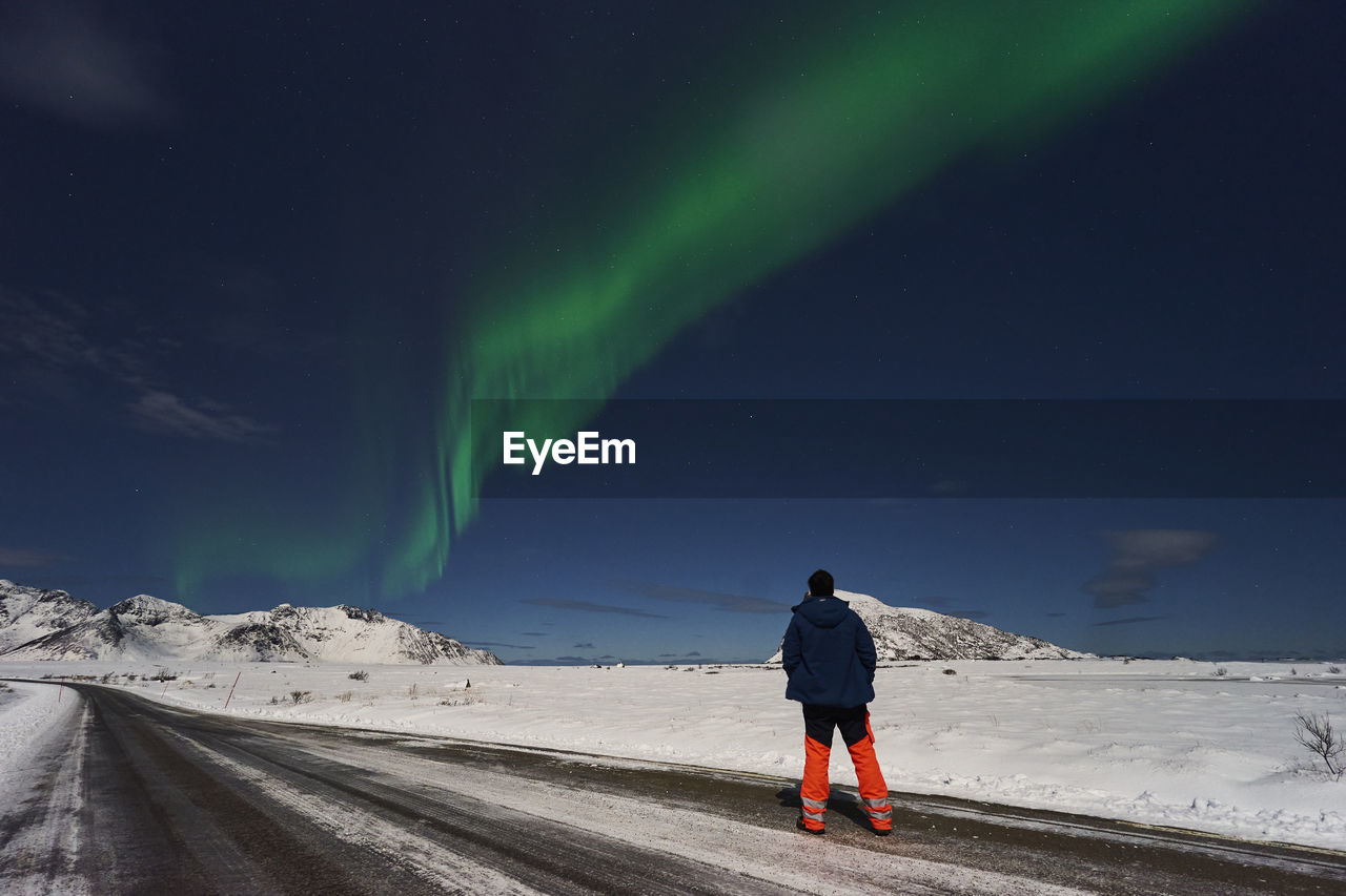 Rear view of man walking on snow