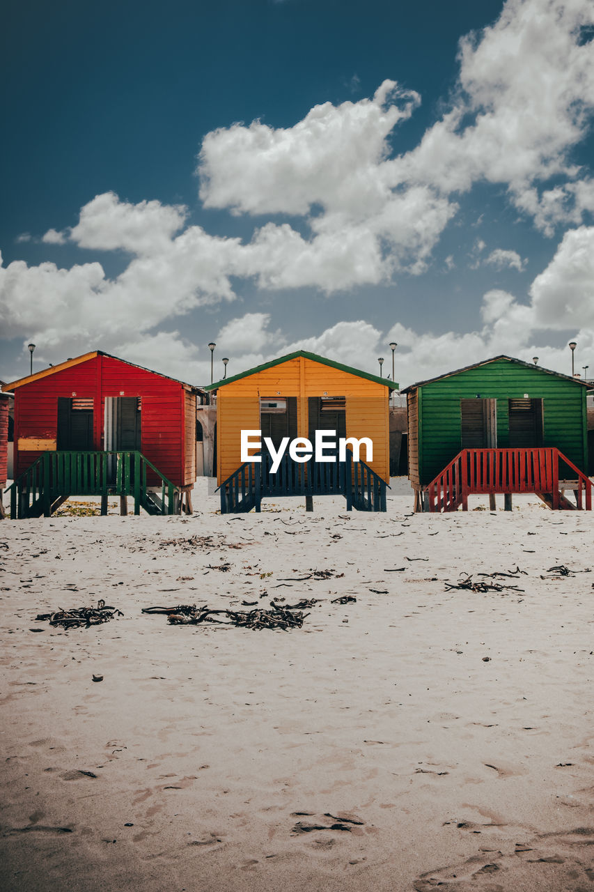 Beach huts by buildings against sky on sunny day muizenberg cape town africa 