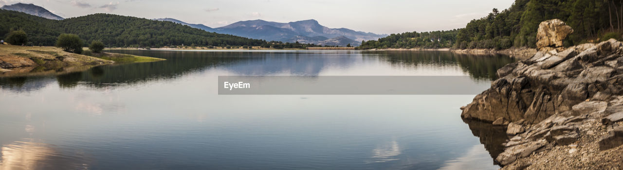 Scenic view of river amidst mountains against sky