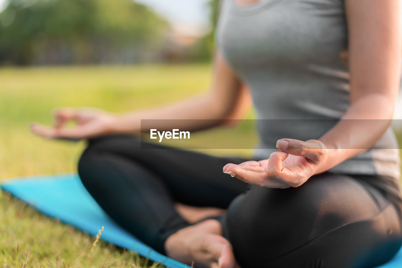 Low section of woman doing yoga in park