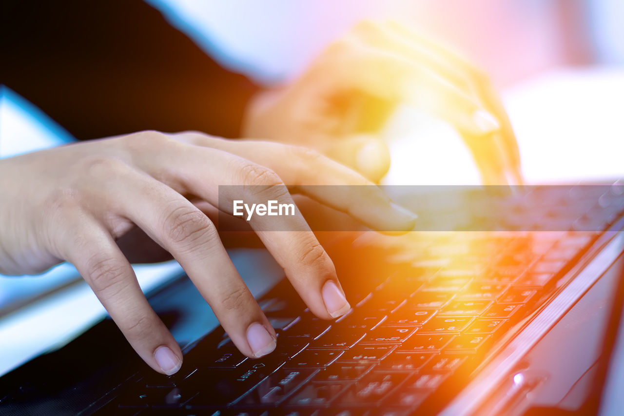 Cropped hands using laptop on desk