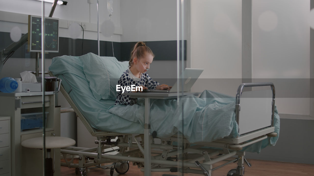 Midsection of woman using digital tablet while standing in hospital