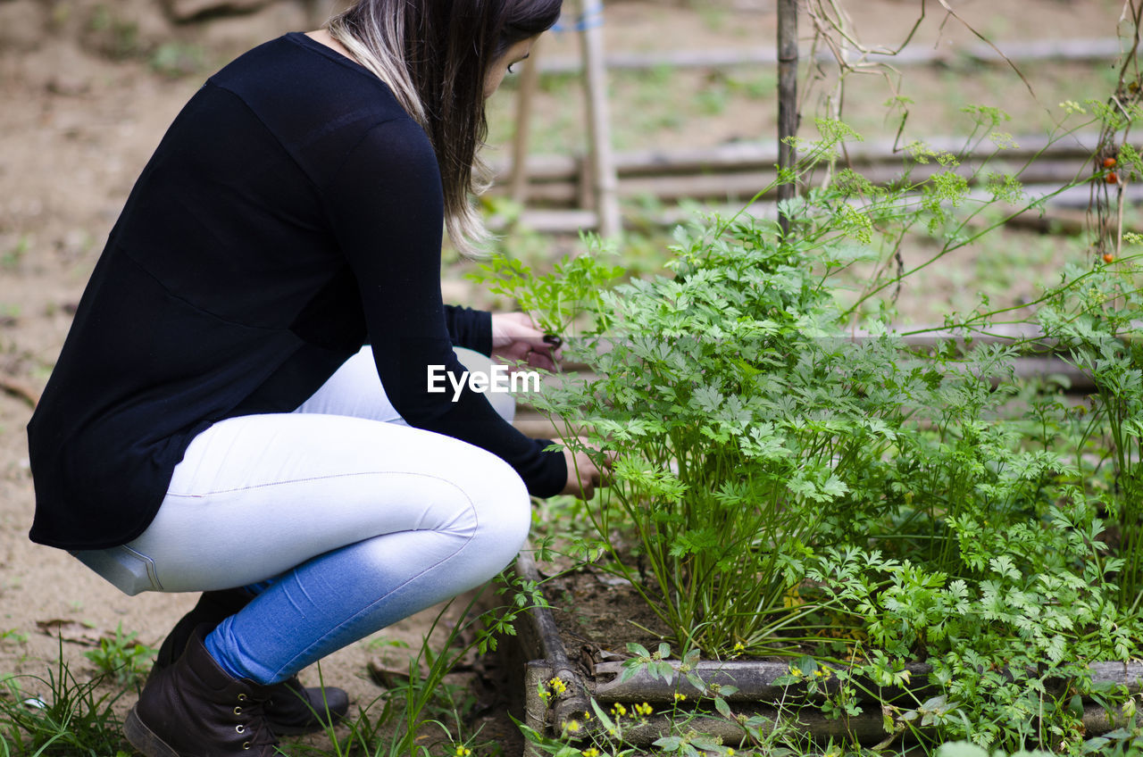 Side view of young woman sitting on land