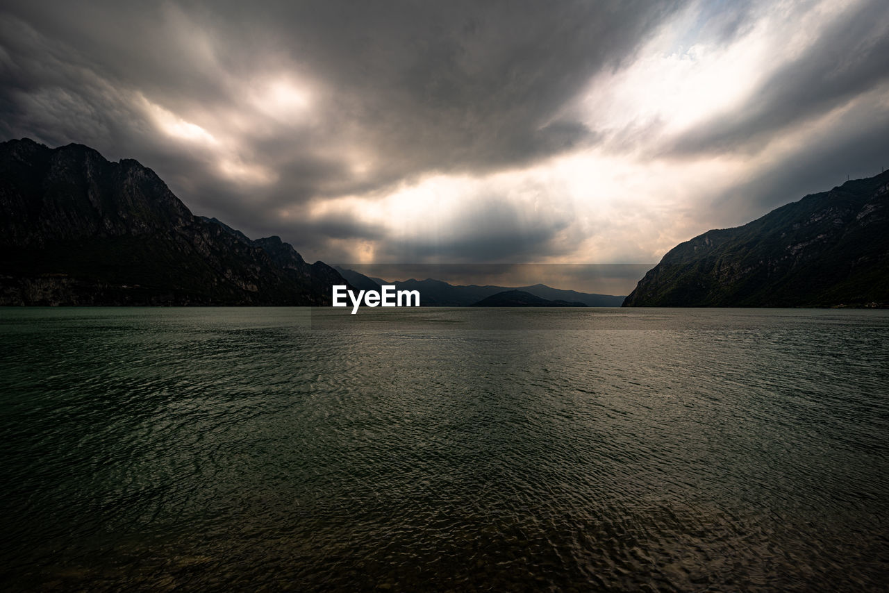 Scenic view of sea and mountains against sky