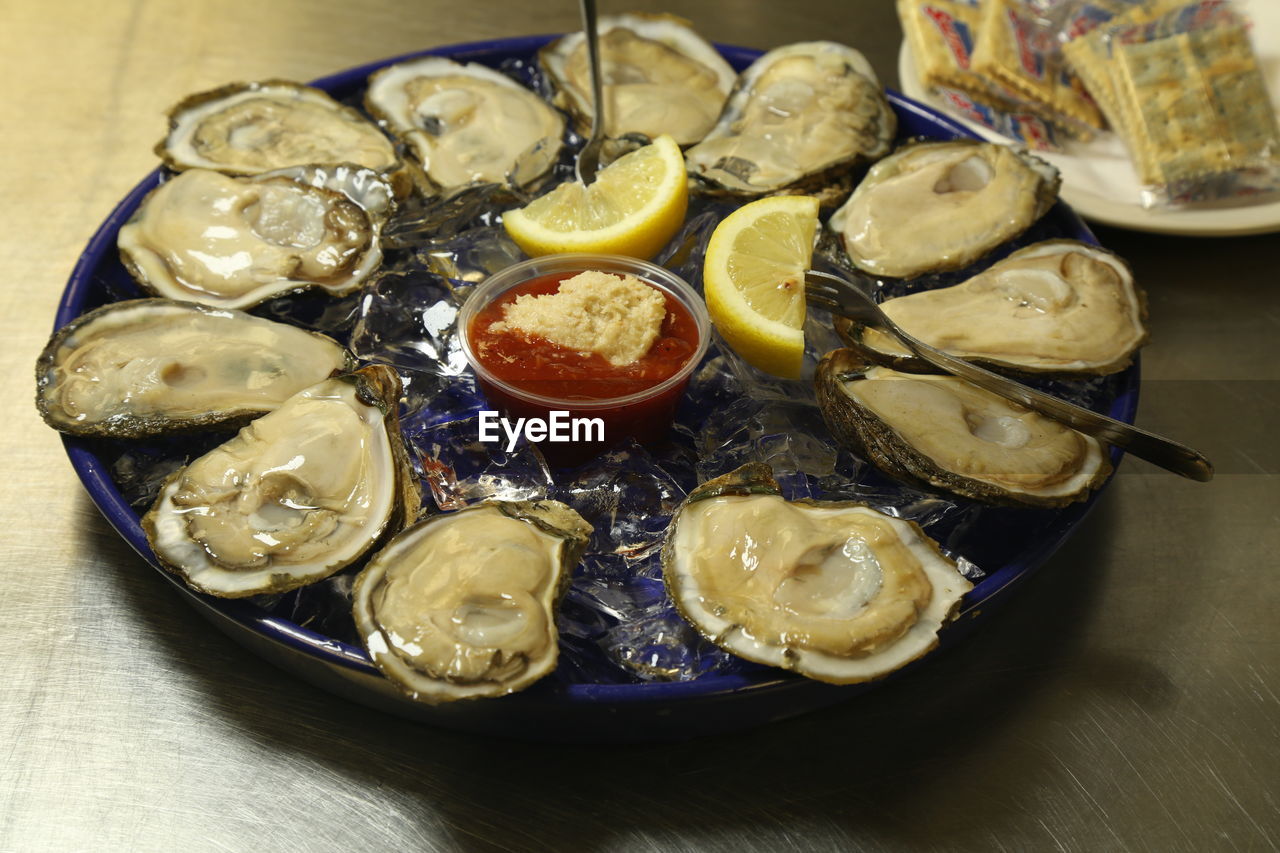 food and drink, food, oyster, seafood, freshness, healthy eating, animal, citrus fruit, table, indoors, wellbeing, fruit, lemon, shellfish, mussel, dish, no people, high angle view, plate, still life, clam, close-up, slice, serving size, meal, fish