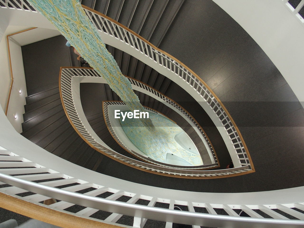 DIRECTLY BELOW SHOT OF SPIRAL STAIRCASE OF BUILDING